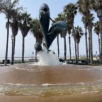 the dolphins fountain at stearns wharf surrounded by palm trees